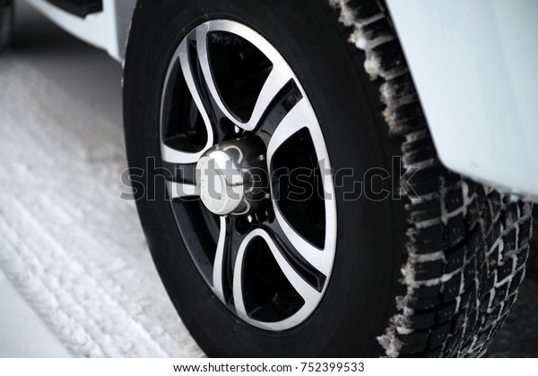 Car wheel\
with winter tires is in the snow\
close-up