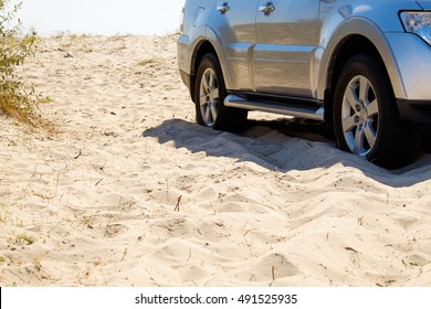 Car wheels on a sea beach sand. Off-road tire on summer seashore. Outdoor, adventures and travel suv. Close-up of car wheel on sandy dunes in countryside with ocean in background. - Powered by Shutterstock