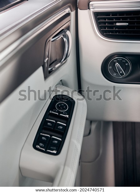 Car white leather interior detail. Windows\
control buttons and door\
handle.