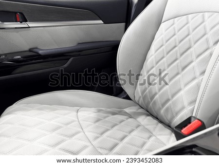 Car white leather interior. Part of white leather car seat details with white stitching. Interior of prestige car. Comfortable perforated leather seats. Perforated leather.