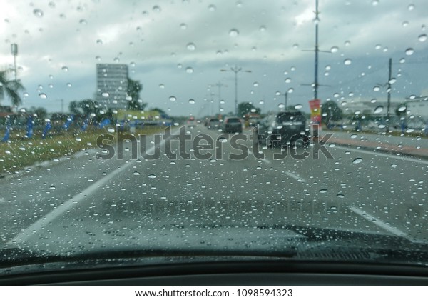 Car\
window covered with rain droplets, rainy weather during spring\
season. Raindrop on the car glass with blurred background. Rain\
drops on the car glass. Water drops on the car\
glass.