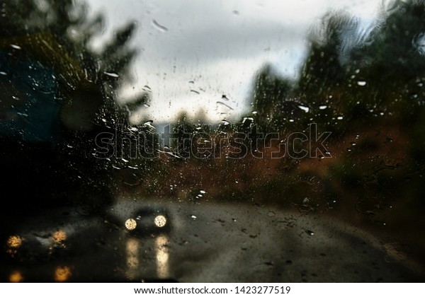Car window with rain drops. Driving in rain.\
Weather background. Rainy\
glass.