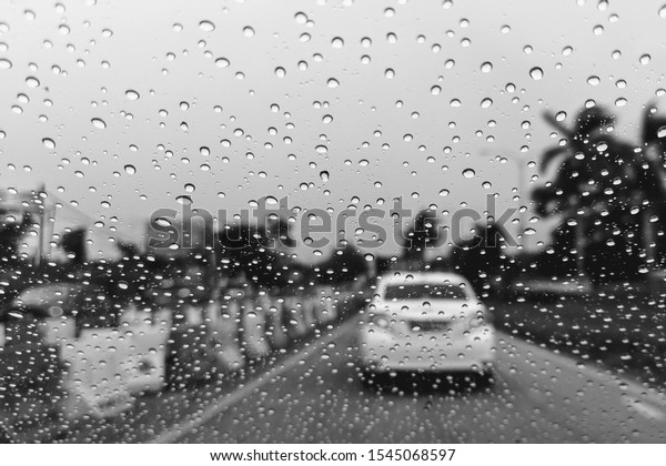 Car window with rain drops. Driving in
rain. Weather background. Black and white photo rain drops on glass
sad mood bad weather rainy window
sadness.
