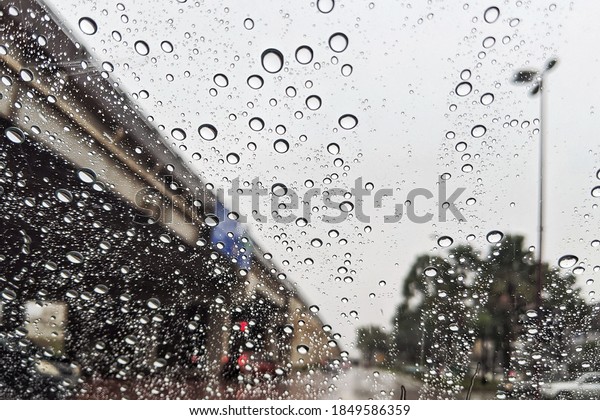 Car window with rain drops. Driving in\
rain. Weather background. Selective\
focus.