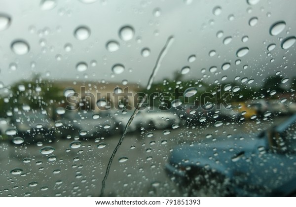 car window with raindrops and driving cars\
seen able though the window on rainy day\
