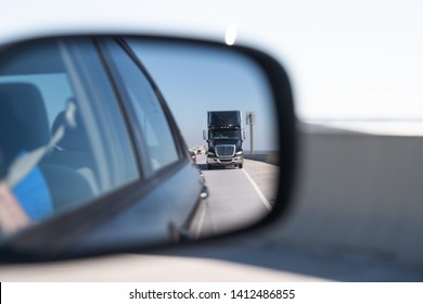 Car window side mirror on sunny day with truck traffic in reflection in Florida transportation highway street road - Powered by Shutterstock