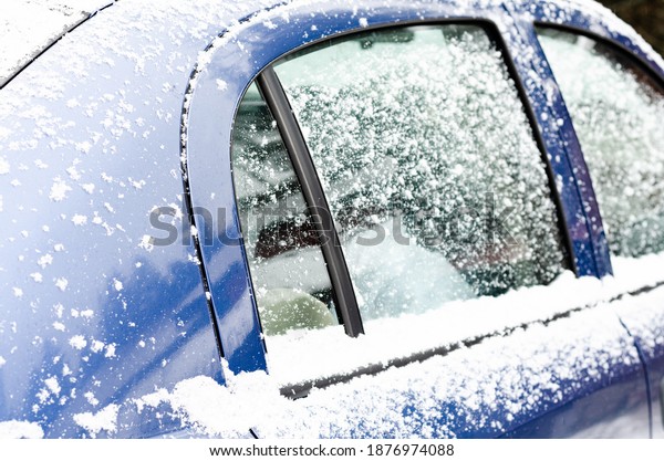 Car\
windows and wipers covered with snow in\
winter