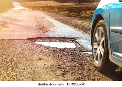 Car And Winter Pothole On Open Road