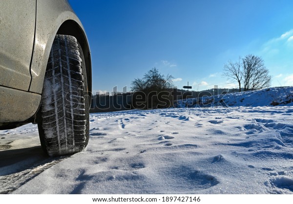 Car in winter in the snow.\
Winter tires. Winter landscape with sun and blue sky in the\
background.
