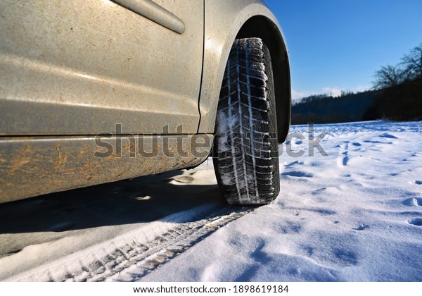 Car in winter in the snow.\
Winter tires. Winter landscape with sun and blue sky in the\
background.