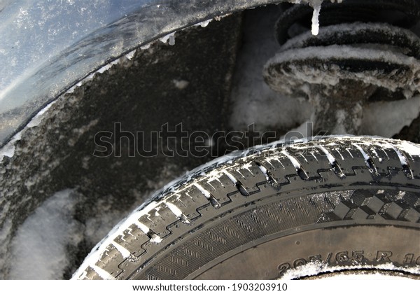 A car with winter tires with snow and ice. Car winter\
tire. 