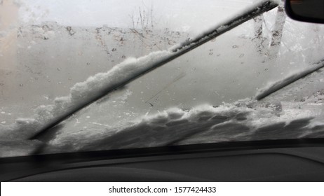 Car Wiper Blades Clean The Iced Windshield From Snow, Inside View - Winter Cold Start, Snowstorm, Snowfall, Safety Winter Driving