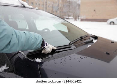 Car Wiper Blades Replacement , Seasonal Vehicle Maintenance, Female Hand With Warm Glove On Vehicle Windshield Outdoor At Cold Winter Day