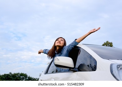 Car woman on road on road trip waving happy smiling out the window.  