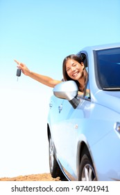 Car Woman Showing Keys Excited, Happy And Joyful. Young Woman Driver Smiling In Her New Car. Mixed Race Asian / Caucasian Female Model Above The Clouds On Beautiful Summer Day.