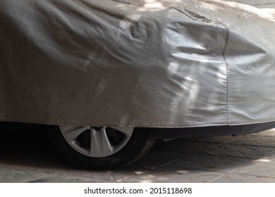 Car With Worn And Dusty Gray Cover. Dusty Cover. Unused Car Inside Garage.