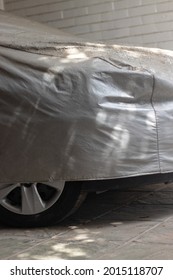 Car With Worn And Dusty Gray Cover. Dusty Cover. Unused Car Inside Garage.