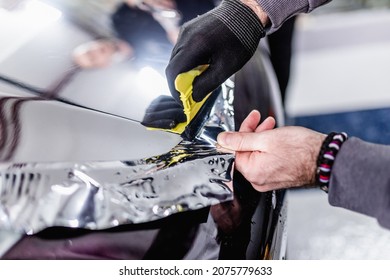 Car Wrapping Specialist Putting Silver Mirror Chrome Foil On Car. Selective Focus. 