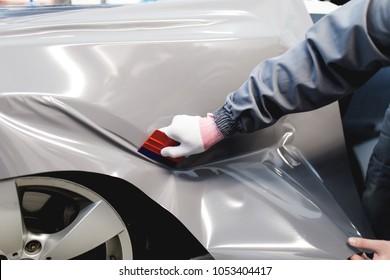 Car Wrapping Specialist Putting Vinyl Foil Or Film On Car. 