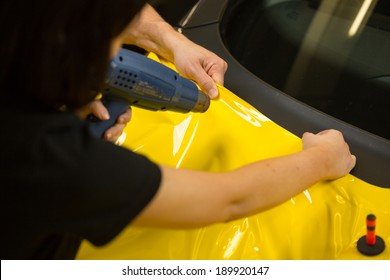 Car Wrapping Specialists Using Heat Gun To Prepare Vinyl Foil 