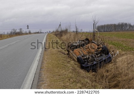 car wreck lying in a roadside ditch
