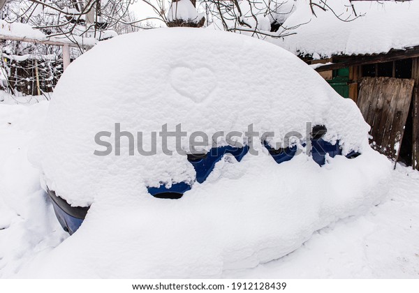 Car in the yard with a\
large snowdrift
