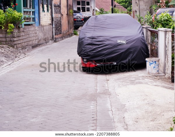 the\
car in yard. Yogyakarta, Indonesia, September 28, 2022, mantol\
mobil untuk melindungi mobil dari sinar matahari dan terkena debu\
di luar rumah atau garasi, parkir di pinggir\
jalan