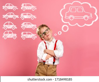 A Car Of Your Dreams. Little Businessman Dreams About A Car. Stylish Kid Boy Isolated On Pink With Cars Drawing Overhead