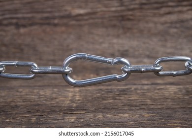 carabiner hook and round link chain on wooden table