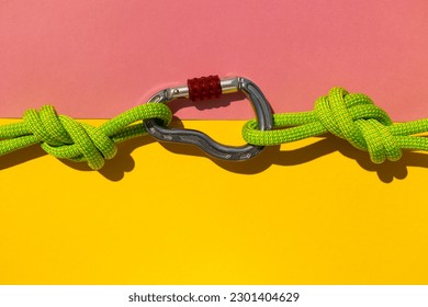 carabiner with a rope lies on a colored background. Equipment for climbing and mountaineering. reliable connection. Safety rope. Node eight. the concept of reliability and strength. copy space.