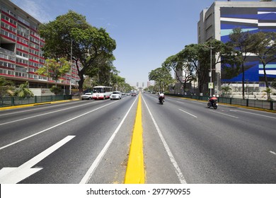 CARACAS, VENEZUELA, APRIL 20: Avenue with small traffic, bus, cars and motos, early in the morning in Caracas against a blue sky, Venezuela 2015.
