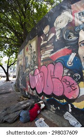 CARACAS, VENEZUELA, APRIL 20: Unrecognizable Poor Man Sleeping On The Street Of Caracas With A Graffiti Of Simon Bolivar. High Poverty Rate In Venezuela Due To The Economical Inflation In 2015.