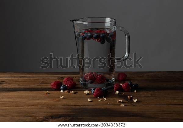 carafe\
full of fresh water with raspberry and\
blueberry