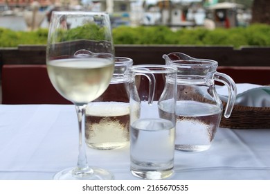 Carafes with white wine and water, a wine glass, a water glass
