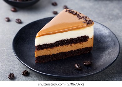 Caramel cake, mousse dessert on a plate. Grey stone background. 