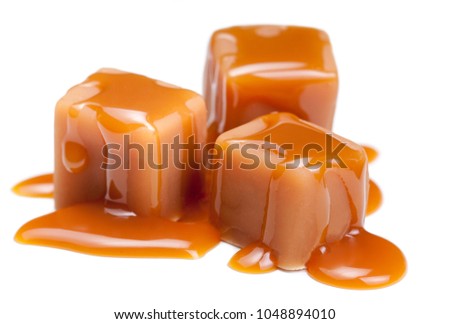 Caramel candies with caramel sauce isolated on a white background close up. 
