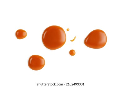 Caramel drops of sweet caramel sauce isolated on white background. Melted liquid toffee. Top view. 