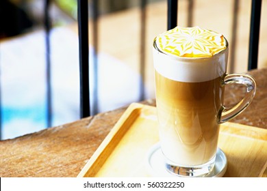 Caramel Macchiato In Long Clear Glass On Wooden Table.