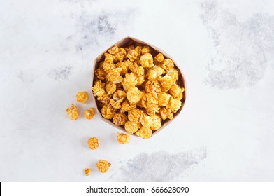 Caramel popcorn in a paper bag on gray background. A place for a label - Powered by Shutterstock