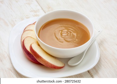 Caramel Sauce In A Bowl And Apple Slices On A White Plate