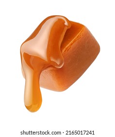 Caramel sauce flowing on caramel cube isolated on white background. Caramel candy with liquid caramel.