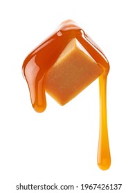 caramel sauce flowing on flying caramel candy isolated on white background