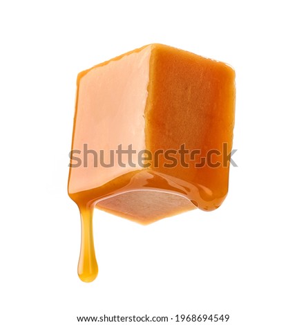 caramel sauce flowing on flying caramel candy isolated on white background