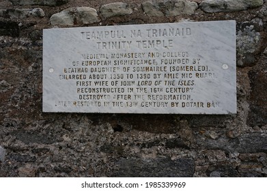 Caranish, Scotland, UK - June 3 2021: Sign At Teampull Na Trianaid Trinity Temple, North Uist, Outer Hebrides, Scotland. Explains History Of Temple. Weathered Sign Isolated On Stone Wall.