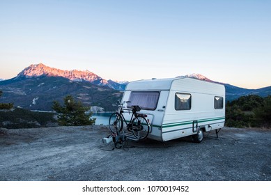 Caravan With A Bike Parked On A Mountaintop With A View On The French Alps Near Lake Lac De Serre-Poncon