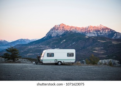 Caravan With A Bike Parked On A Mountaintop With A View On The French Alps Near Lake Lac De Serre-Poncon