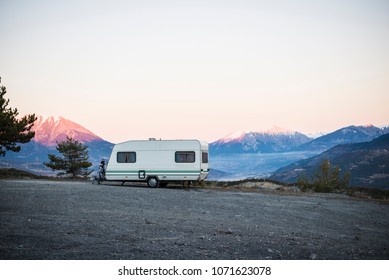 Caravan With A Bike Parked On A Mountaintop With A View On The French Alps Near Lake Lac De Serre-Poncon