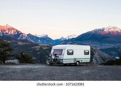 Caravan With A Bike Parked On A Mountaintop With A View On The French Alps Near Lake Lac De Serre-Poncon