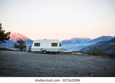 Caravan With A Bike Parked On A Mountaintop With A View On The French Alps Near Lake Lac De Serre-Poncon