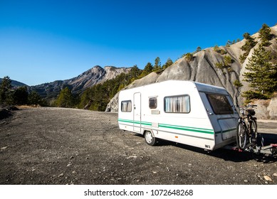 Caravan With A Bike Parked On A Mountaintop With A View On The French Alps Near Lake Lac De Serre-Poncon